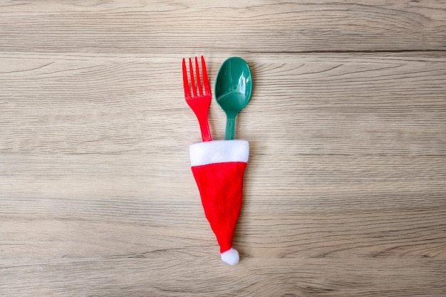 Merry Christmas with miniature Santa Claus fork and spoon on wood table background Xmas party and happy New Year concept