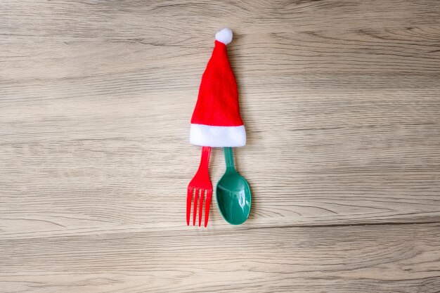 Merry Christmas with miniature Santa Claus fork and spoon on wood table background Xmas party and happy New Year concept