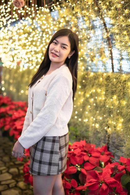 Merry xmassmile happiness portrait beautiful young asian woman wearing warm clothes on Christmas tree light circular bokeh background Decoration During Christmas and New Year Festival illumination