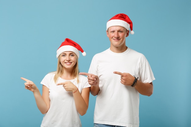 Merry young Santa couple friends guy and woman in Christmas hat posing 