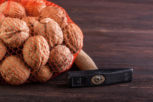 Mesh with walnut and hammer on a wooden background