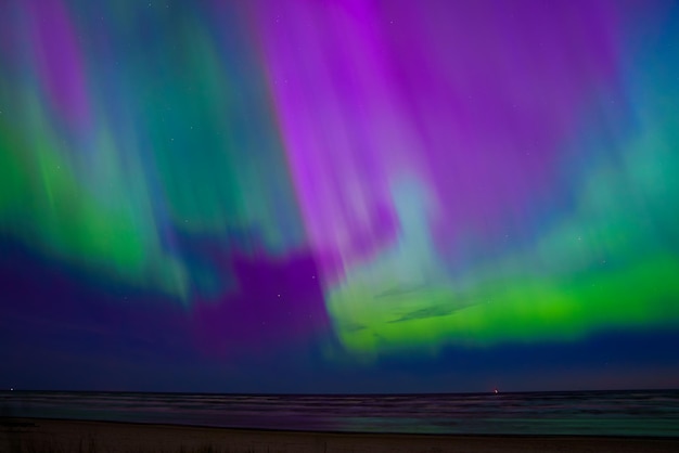 Photo mesmerizing aurora borealis over riga and jurmalas coastal horizon in latvia