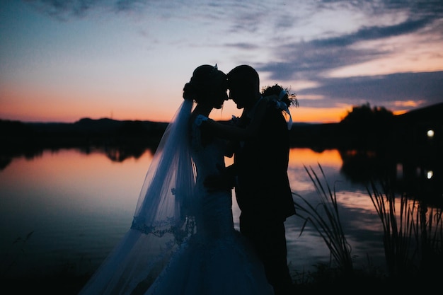 Mesmerizing shot of a couple on the wedding day on the beautiful sunset background