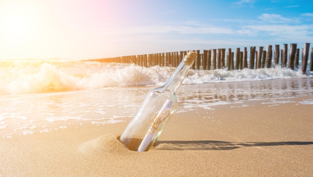 Message in a bottle on the beach with groynes