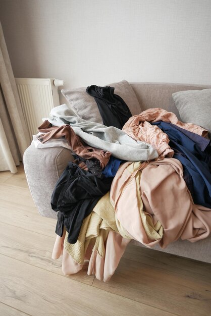 Messy clothes on sofa at home