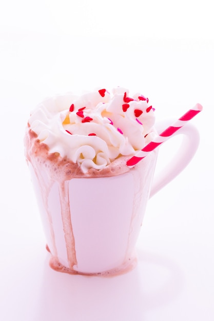 Messy hot chocolate with white and red straw.