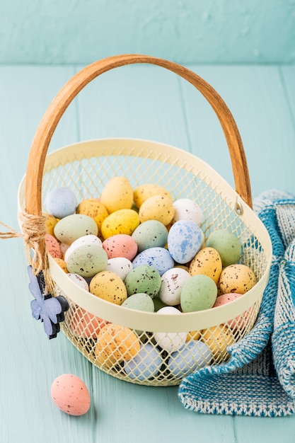 Metal basket with colourful Easter quail eggs. Spring holidays concept with copy space