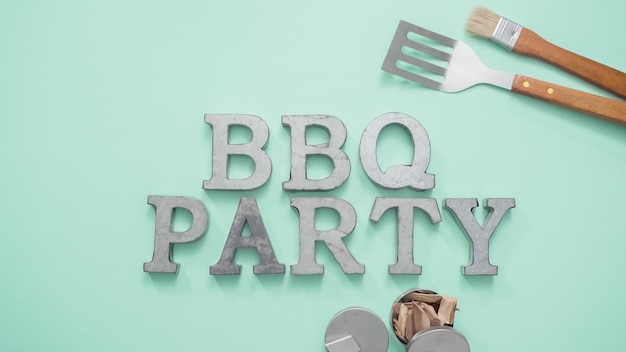 Metal BBQ Party sign with grilling tools on blue background.