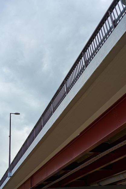 Metal bridge view from below with an overcast sky in the background