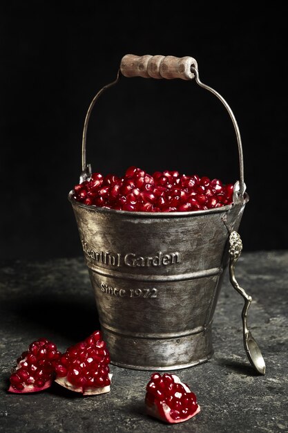 Metal bucket with pomegranate berries.