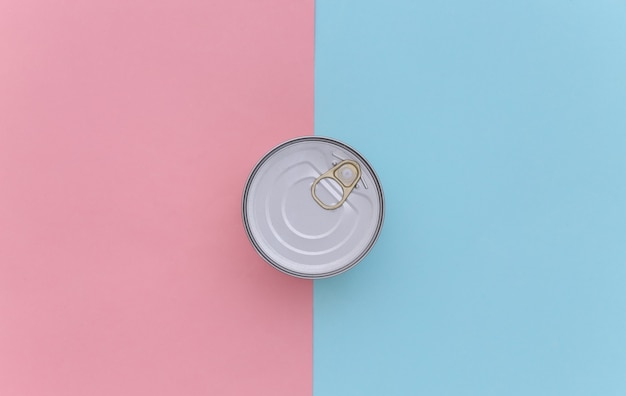 Metal can of canned food on blue pink background. Top view