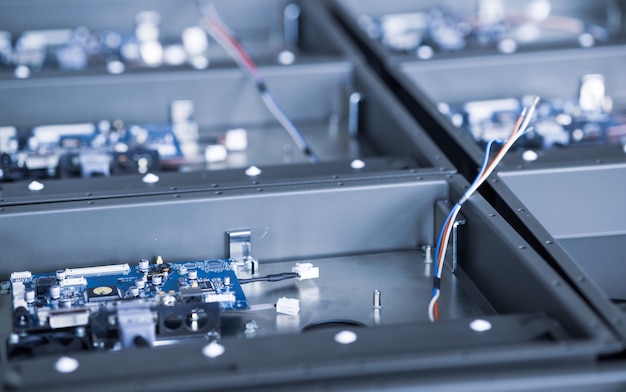 Photo metal components and microcircuits lie on metal compartments during the production of cases of future powerful supercomputers with video fruits. concept production of specialized mining computers