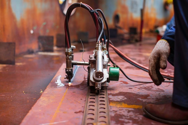 Metal cutting spark on tank bottom steel plate with flash of cutting light close up in side confined space