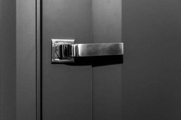 Metal handle on a stylish gray door Closeup Modern trends in decorating and interior design