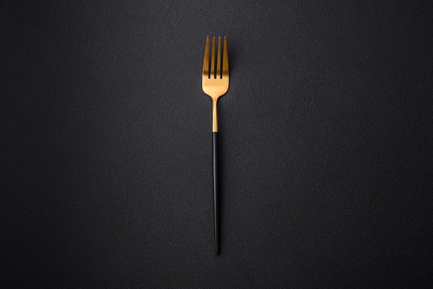 Metal kitchen fork on a dark textured concrete background