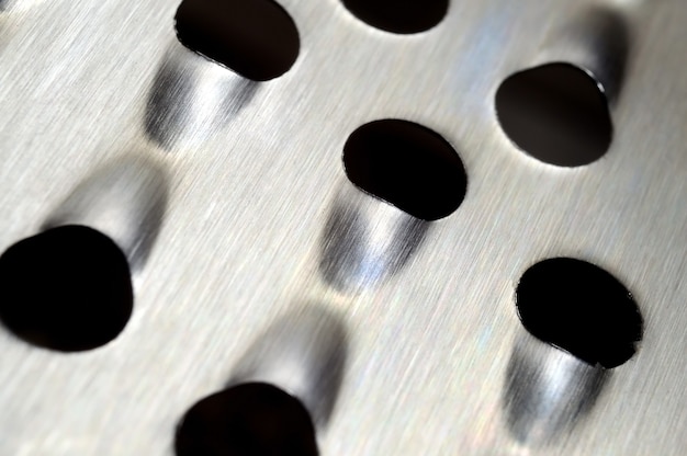 Metal kitchen grater with large holes. macro.