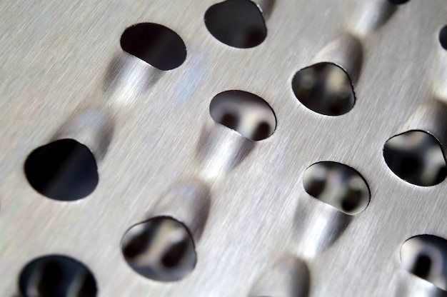 Metal kitchen grater with large holes. macro.