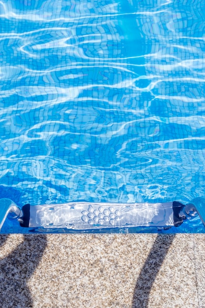 A metal ladder with railing in a swimming pool with tiled floor