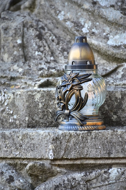 A metal lamp stands on the stone surface of an old crypt