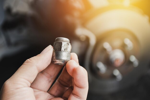 Metal nut of the car wheel in the hand