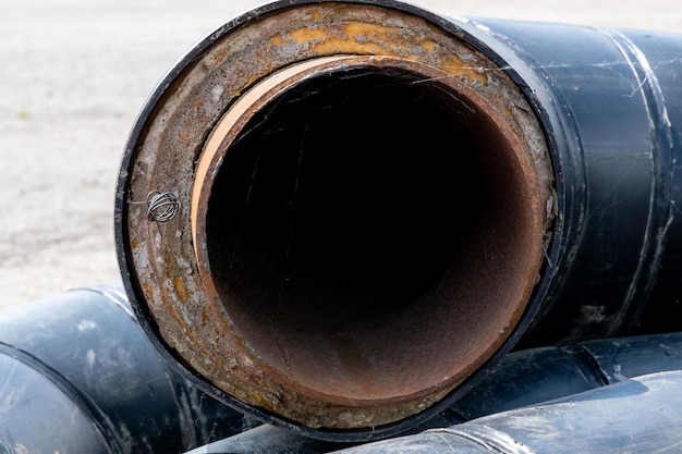 Photo metal pipes rusty inside with black coating on the outside