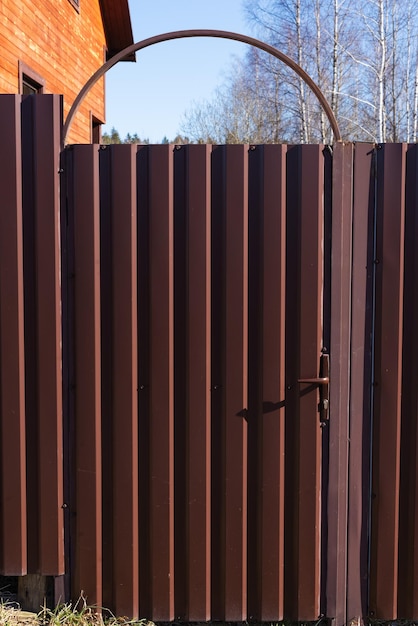 Metal profile door for entrance to country house site Vertical orientation Private property fencing