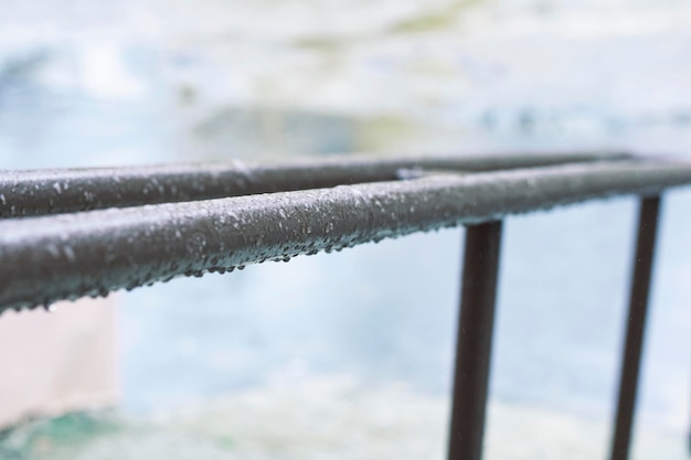 Metal railing with drops of water in the rain