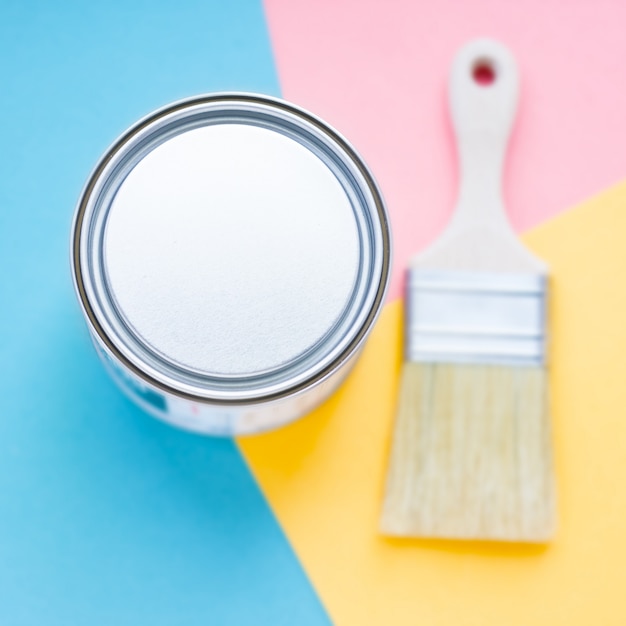 Metal round can on colorful background with new paint brush