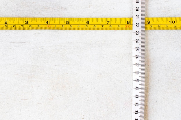 Photo metal ruler and tape measure centimeters and millimeters on the yellow ruler