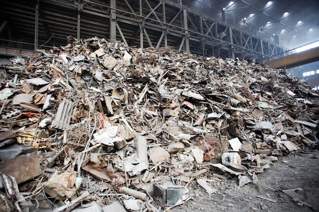 Metal scrap over rusty iron waste at junk yard. Iron raw materials ready for recycling.