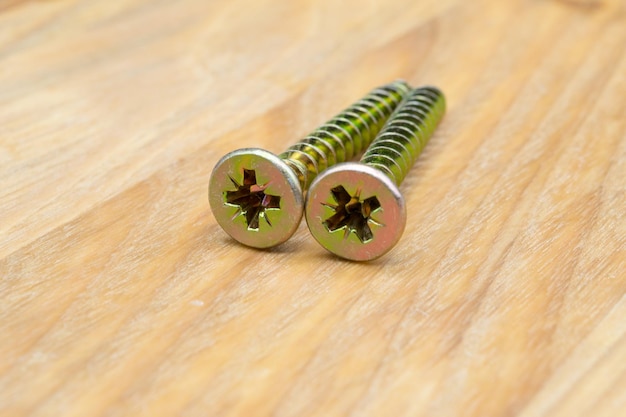 Metal screws for wood Closeup view of metal wood screws on a wooden background