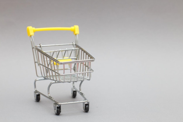 The metal shopping cart on a grey background