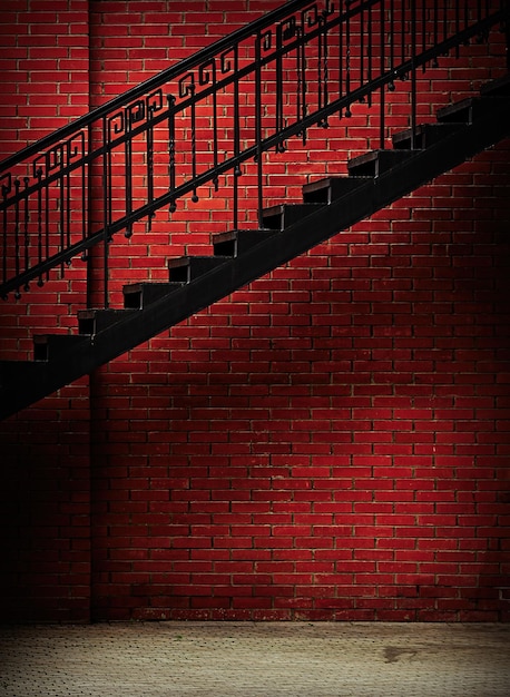 Metal stairway with grunge red brick wall background