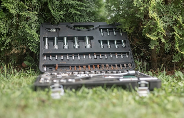 Metal steel repair tools in toolbox on grass outdoors