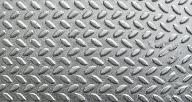 a metal surface with a silver metal surface that has water drops on it