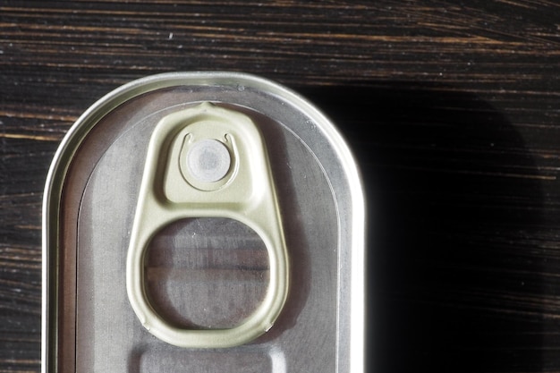 Metal tin can with a key Isolated on black background Close up