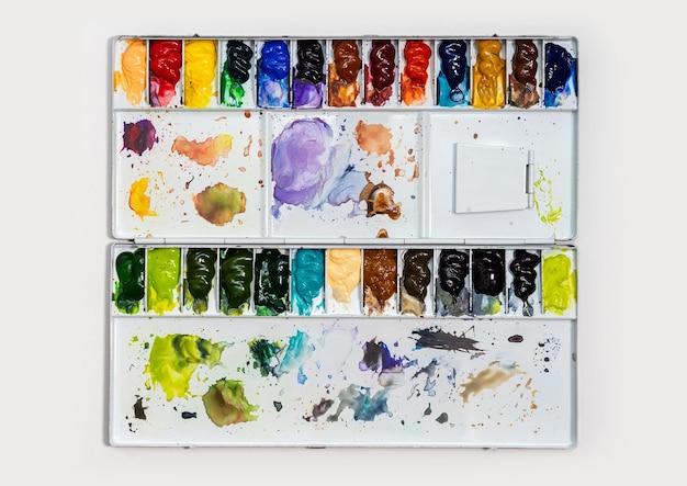 Metal watercolor palette box with colorful watercolor set on a white background