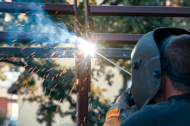 Metal welding in industrial production a man in a welding mask welds a metal structure