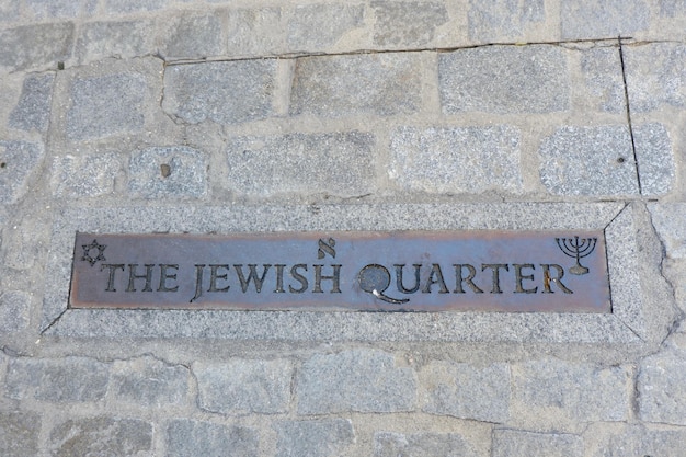 Metallic sign jewish quarter written in english language on street in historical city Toledo Spain