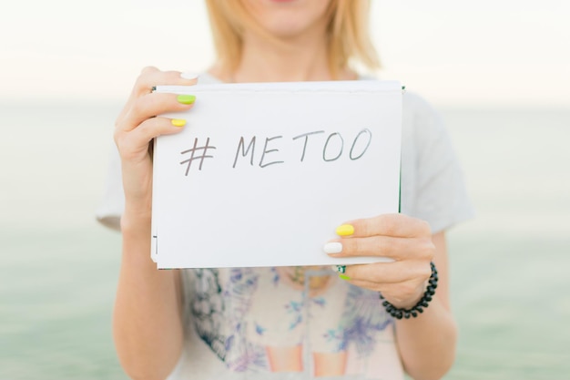 Photo metoo as a new movement a young woman holds a banner with the inscription