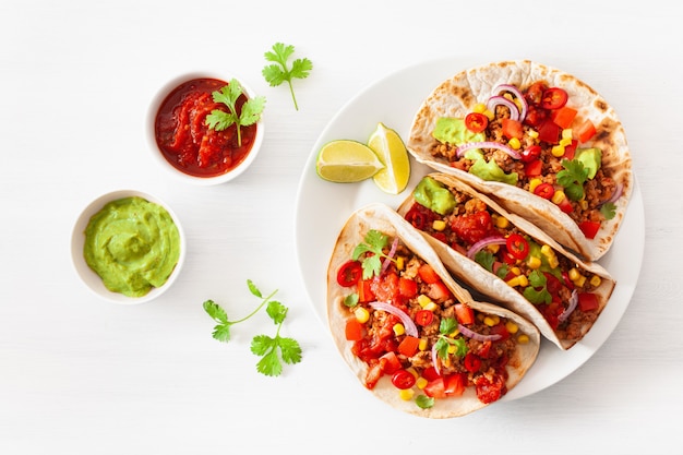 Mexican beef and pork tacos with salsa, guacamole and vegetables