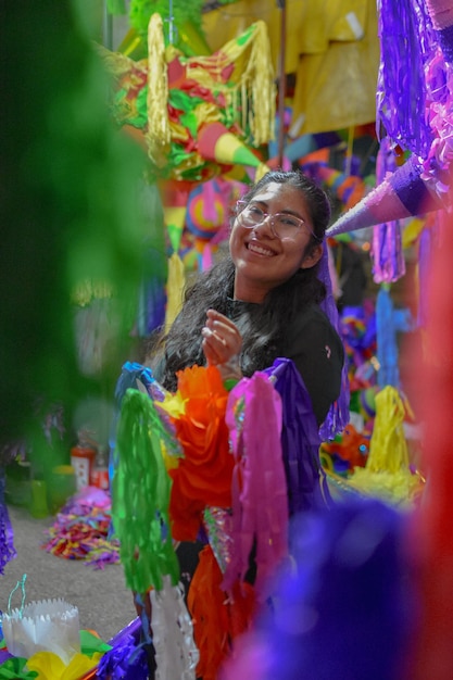 Mexican Christmas Latin Woman Breaking a Piata and celebrating a traditional Posada in Mexico