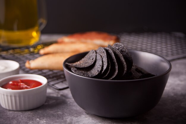 Mexican corn chips nachos and fried meat pies empanadas cheburek with dips. Black chips nachos for brutal men.