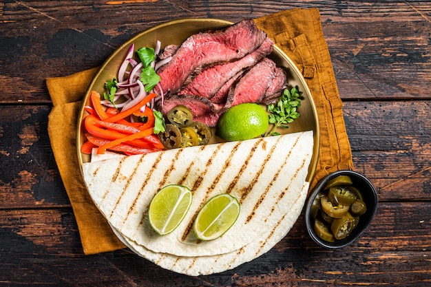 Mexican fajitas for grilled beef steak and vegetables Wooden background top view