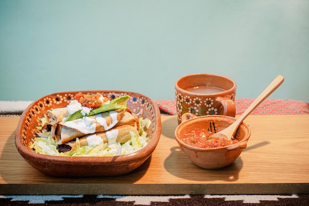 Mexican flautas with lettuce avocado cream sauce and fresh water