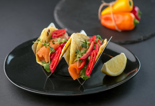 Mexican food Spicy tacos with tomatoes and meat on a dark background