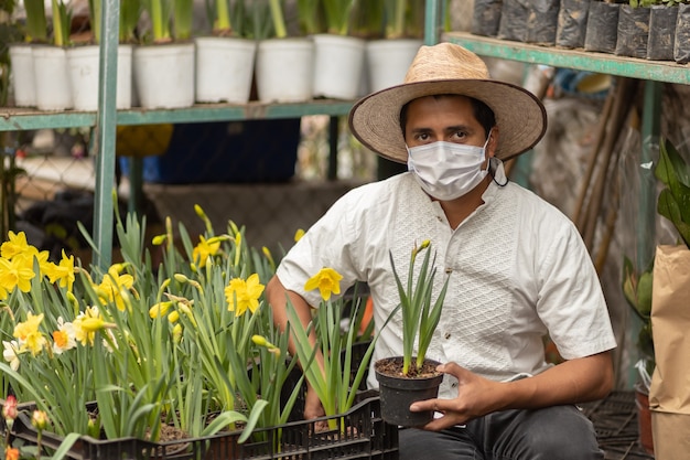 Mexican man working in nursery wearing face mask, new normal