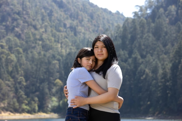 Mexican mother and daughter hugging outdoors women39s day