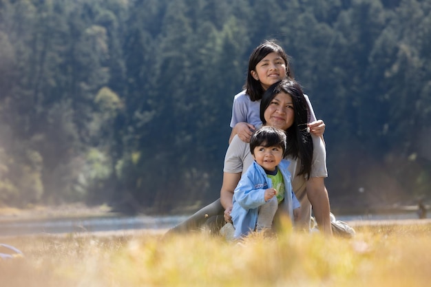 Mexican mother with daughter and son hugging outdoors