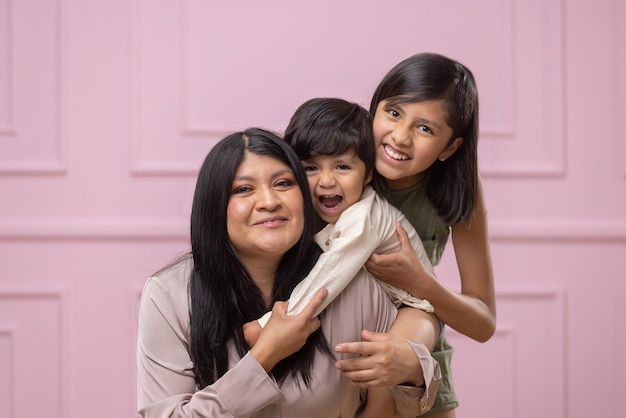 Mexican mother with hugging and laughing with her two children